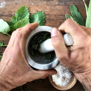 Dettaglio della realizzazione del sale aromatico utilizzando un pestello in marmo.