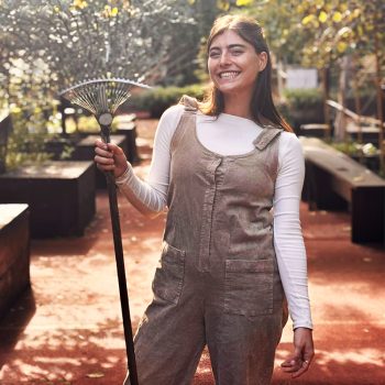 Bianca con un rastello posa agli Orti Dipinti, il Community Garden nel cuore di Firenze.